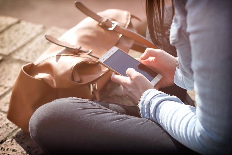 Image of a person using the Tesla app on their smartphone to control their Tesla and access its various features.