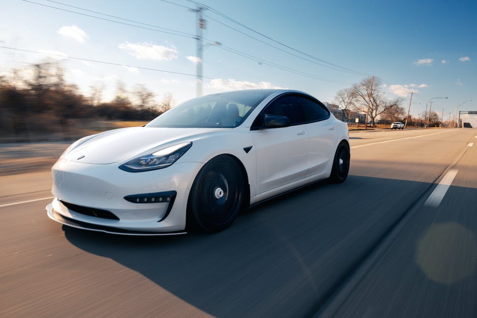 A Tesla car with autopilot technology driving on a highway